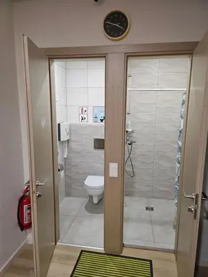 a bathroom with a toilet and a clock on the wall at Kauno apartamentai in Kaunas