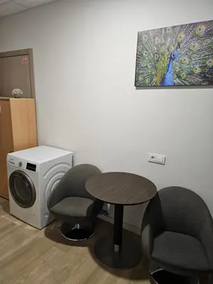 a room with a table and two chairs and a washing machine at Kauno apartamentai su balkonu in Kaunas