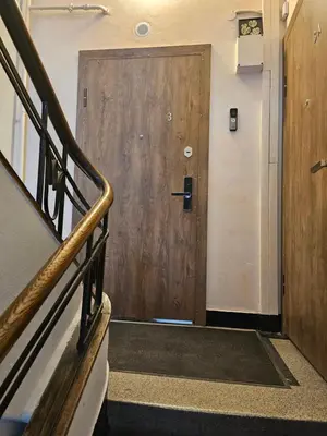 a wooden door in a building with a staircase at Kauno apartamentai su balkonu in Kaunas
