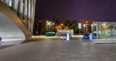 a building with cars parked in a parking lot at night at Nordic Studio In Prime Vilnius Location in Vilnius