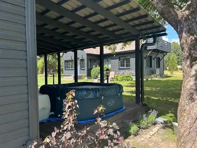 a pergola on a house with luggage under it at Sodyba ramiam poilsiui in Kaltanėnai