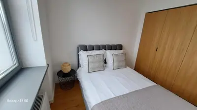 a small bedroom with a bed with white sheets and pillows at KaunasInn - AM in Kaunas