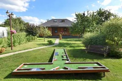 a park with a table with books in the grass at Vasarnamis Zarasuose - Vyšnia in Zarasai