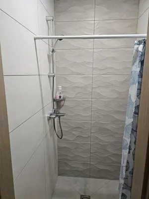 a shower with a glass door in a bathroom at Kauno Apartamentai in Kaunas