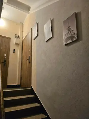 a hallway with stairs and pictures of the eiffel tower at Kauno apartamentai Big room king size bed in Kaunas