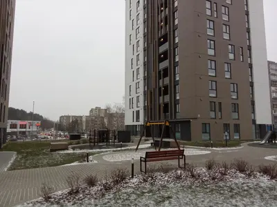 an empty playground in front of a tall building at Apartments with an impressive terrace on the roof of the house in Vilnius