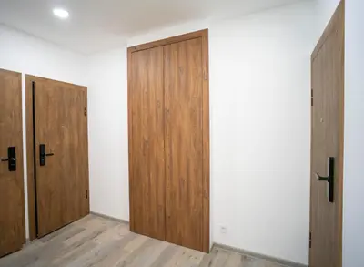 an empty room with wooden doors and wooden floors at Central Station Apartment No5 in Kaunas