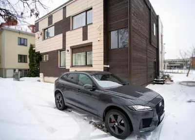 a car parked in the snow in front of a house at Central Station Apartment No5 in Kaunas