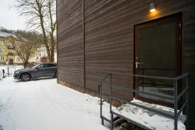 a car parked next to a building in the snow at Central Station Apartment No4 in Kaunas