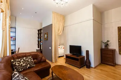 a living room with a couch and a television at Central apartments 2 x Free Parking x SELF CHECK-IN 24h by H&H in Vilnius