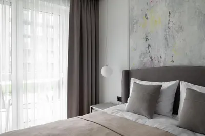 a bedroom with a bed with a large window at No. 2 PARK AVENUE APARTMENT in Kaunas