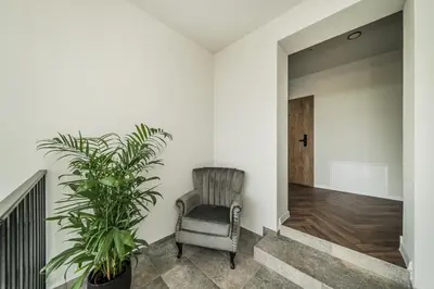 a hallway with a chair and a potted plant at Riverra House - Two-bedroom Apartment in Kaunas