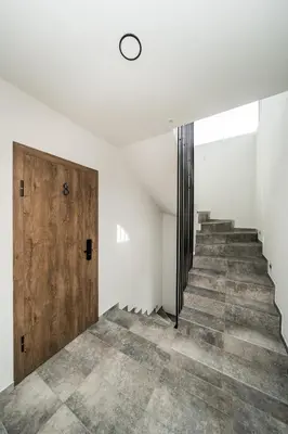 a hallway with stairs and a wooden door at Riverra House - Studio Panorama View in Kaunas