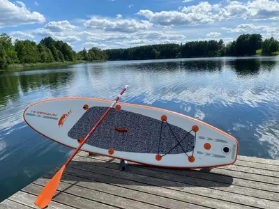 a boat sitting on a dock on a lake at Pineplace trio KOPA in Žaugėdai