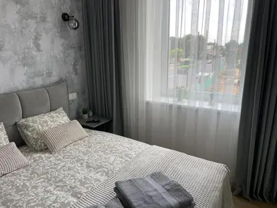a bedroom with a large bed with a window at Žaliakalnis Suites in Kaunas
