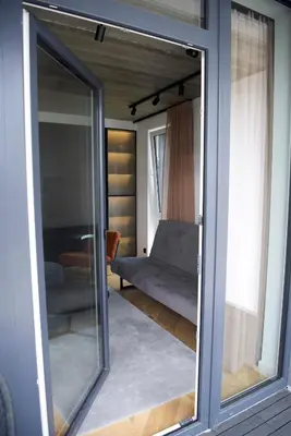 a large glass window in a room with a couch at Ralio apartamentai in Vilnius