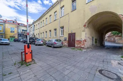 a building with cars parked in a parking lot at Serenade Old Town apartment with AC in Kaunas