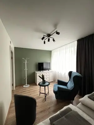 a living room with a couch and a chair at Jaukus butas arti Šiaulių miesto in Šiauliai