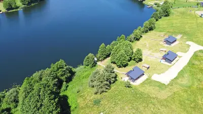 an aerial view of a farm with a lake at Pineplace trio BANGA in Žaugėdai