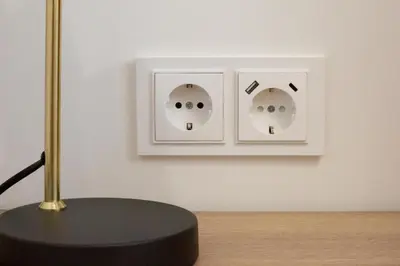 a table with a lamp and two light switches on a wall at Rossak apartment 2 in Panevėžys