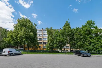 two cars parked in a parking lot in front of a building at Partizanų studio apartment #2 by Polo Apartments in Kaunas