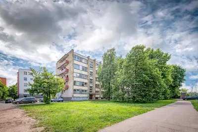 an apartment building with a green lawn in front of it at Partizanų studio apartment #2 by Polo Apartments in Kaunas