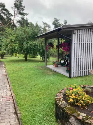 a garden with a pavilion and flowers in a yard at Atostogu namelis in Anykščiai