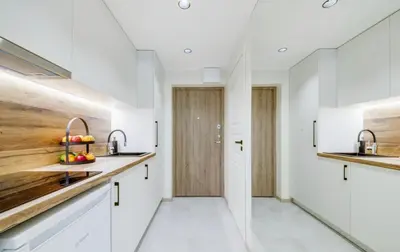a kitchen with white cabinets and a sink at Zveryno apartment in Vilnius