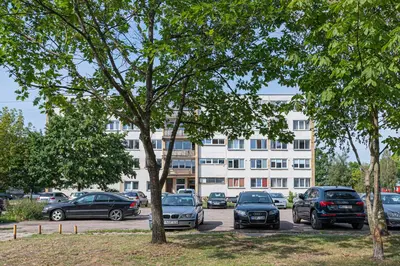 a parking lot with cars parked in front of a building at Pramones apartment #1 by PoloApartments in Kaunas
