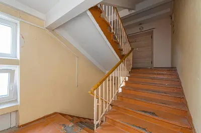 an empty room with a wooden staircase with a door at Pramonės apartment #2 by PoloApartments in Kaunas