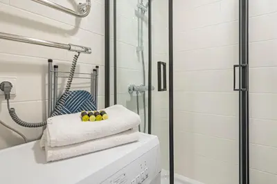 a bathroom with a shower and three towels at Pramonės apartment #2 by PoloApartments in Kaunas