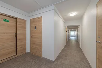 an empty hallway with wooden doors and a corridor at Pramonės Apartment #6 by PoloApartments in Kaunas