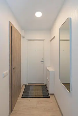 a hallway with a white door and a mirror at Pramonės Apartment #7 by PoloApartments in Kaunas