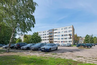 a parking lot with cars parked in front of a building at Pramonės Apartment #8 by PoloApartments in Kaunas