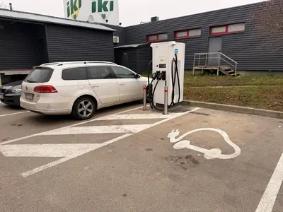 a white car parked next to a gas pump at Chic Residence apartament 3 in Šiauliai