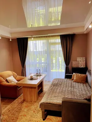 a bedroom with a bed and a couch and a table at Studio FAMILY like home in Vilnius