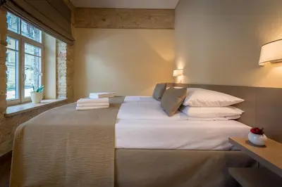 a bedroom with a large bed with white sheets and pillows at New Town Home in Vilnius