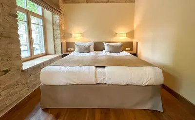 a bedroom with a large bed with white sheets and pillows at New Town Home in Vilnius