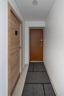 an empty hallway with a door and a rug at Studio Apartment Flora by PoloApartments in Kaunas