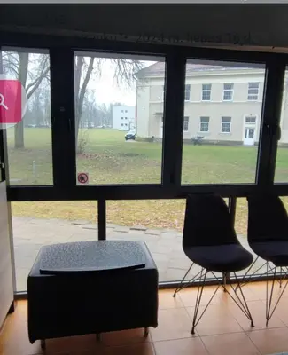 two chairs and a ottoman in front of a window at Amber Apartament in Druskininkai