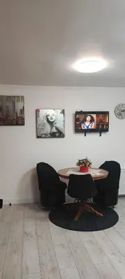 a room with a table and chairs and pictures on the wall at Amber Apartament in Druskininkai