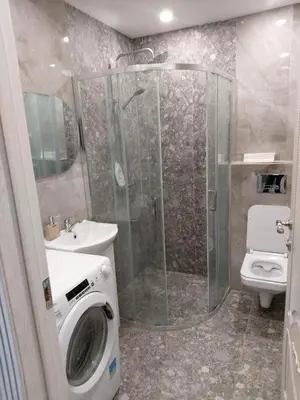 a bathroom with a shower and a washing machine at Gilužio Apartments in Vilnius