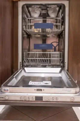 an open dishwasher with a dish rack in it at Hygge Oasis for family with free parking and wi fi in Vilnius