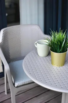 two plants on a table with a chair at Parko Aveniu Apartamentai B2 in Birštonas