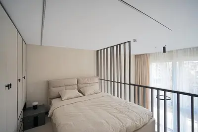 a white bedroom with a bed on a balcony at K32 Loft in Vilnius