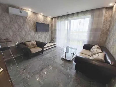 a living room with two couches and a television at Apartamentai prie ežero in Vilnius