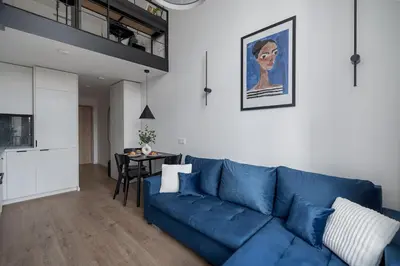 a living room with a blue couch and a table at Loft 60 with Free parking in Vilnius