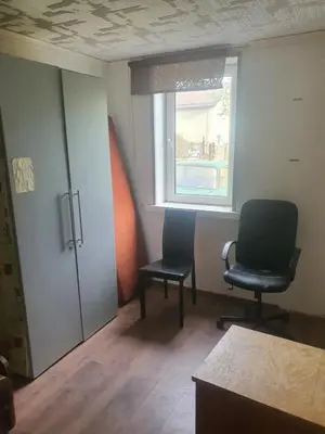 an empty room with two chairs and a window at Hostelis in Rudamina