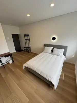 a bedroom with a large white bed and wooden floors at 6 New Airport Apartment in VNO
