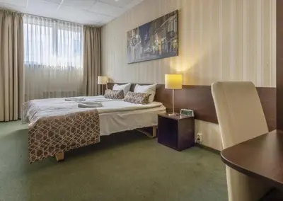 a hotel room with a bed and a table at Naujamiescio Studio 305 in Vilnius